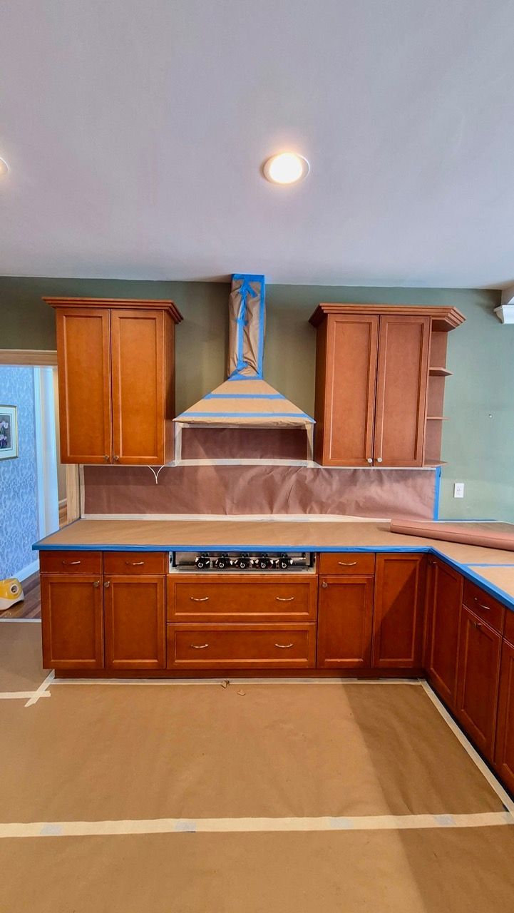 Before photo of Medfield MA kitchen with raised-panel wood cabinets in honey stain and stainless steel appliances before Laperle Painting transformation