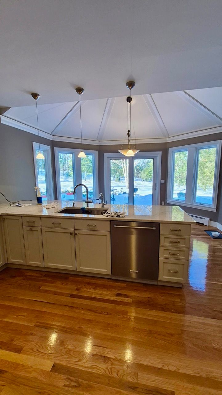 Kitchen island with white painted cabinets and octagonal tray ceiling after cabinet painting by Laperle Painting in Medfield MA