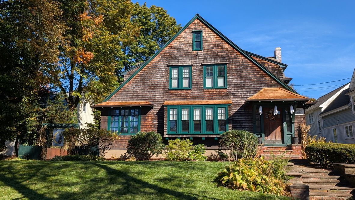 Completed cedar shingle roofs over windows and front entrance on a historic 1910 Medfield, MA home