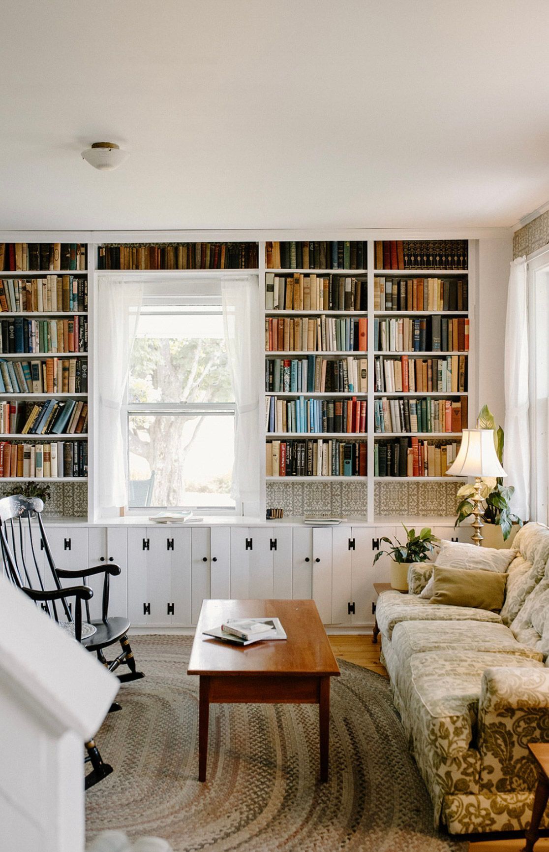 Cozy living room with built-in bookshelves, a floral couch, and a small wooden table.
