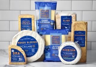 Assortment of Jasper Hill Farm cheeses on a white counter against a tiled wall.