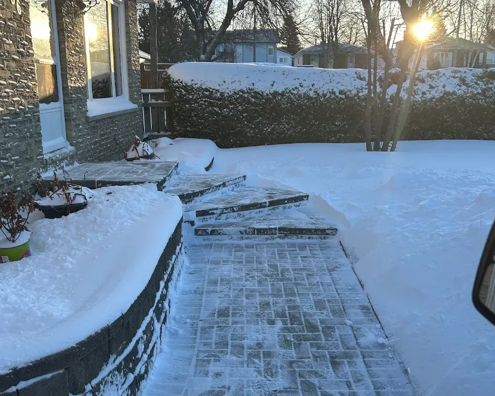 shoveled paver walkway and steps in front of a grey brick house, timmins snow removal