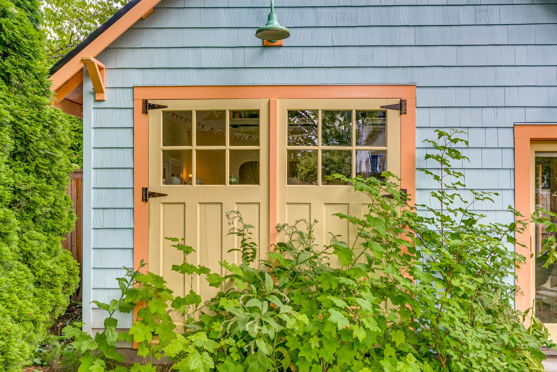 The original garage doors in fresh persimmon and curry yellow on the front of the garage-turned-studio.