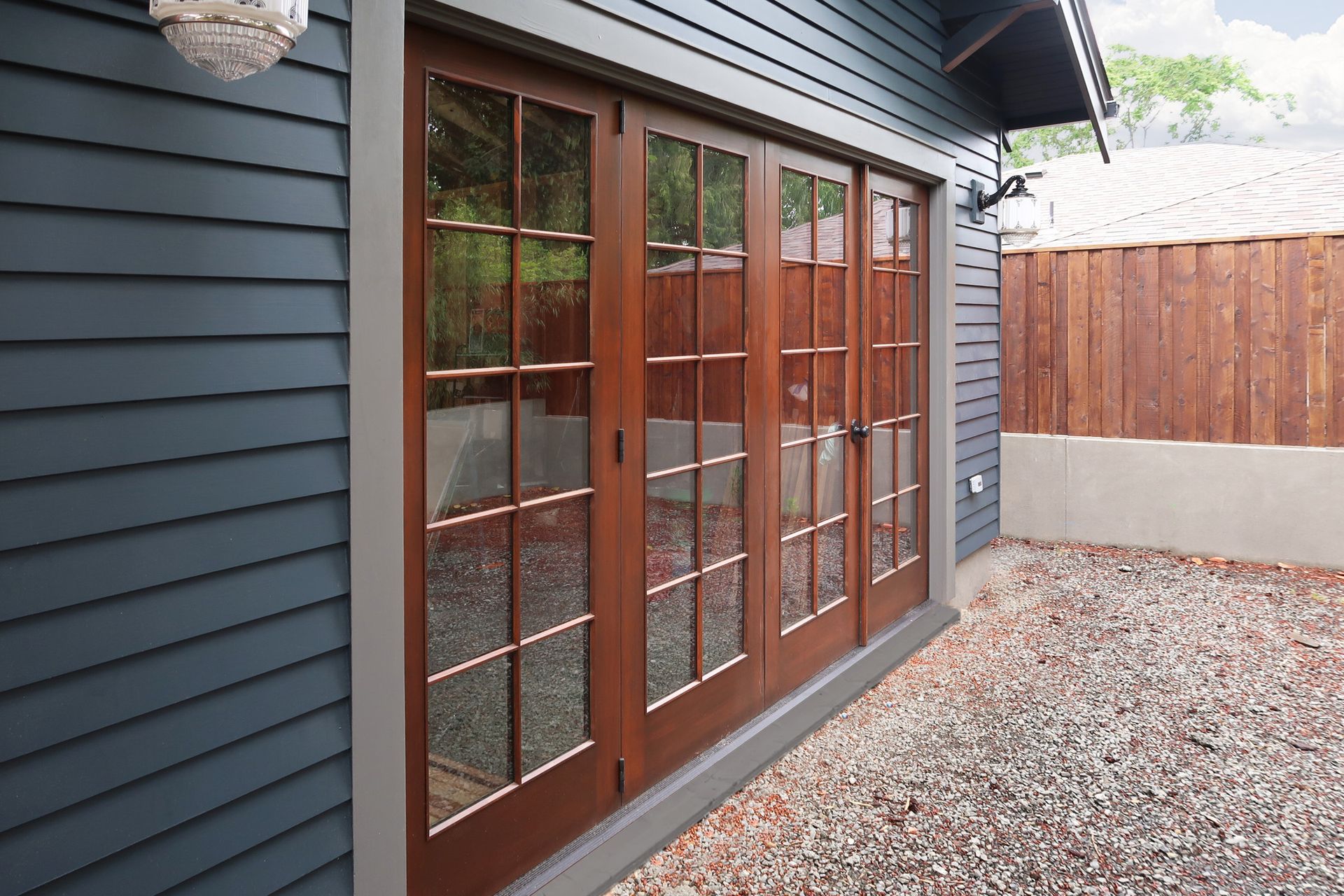 4 custom wood doors face the yard on the back of the restored garage.