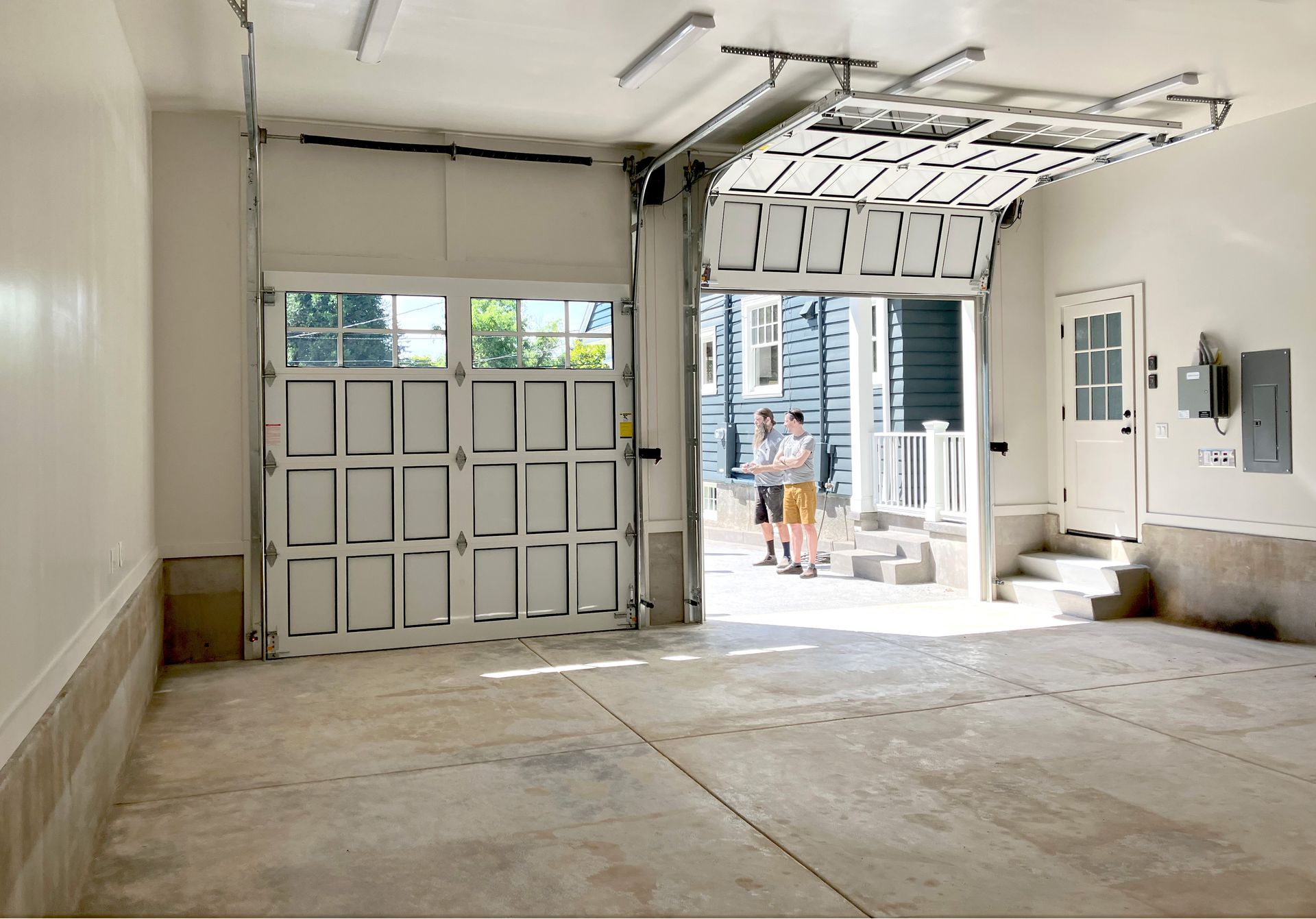 View of two garage doors from the back of the expanded garage, with room for two cars and family storage.