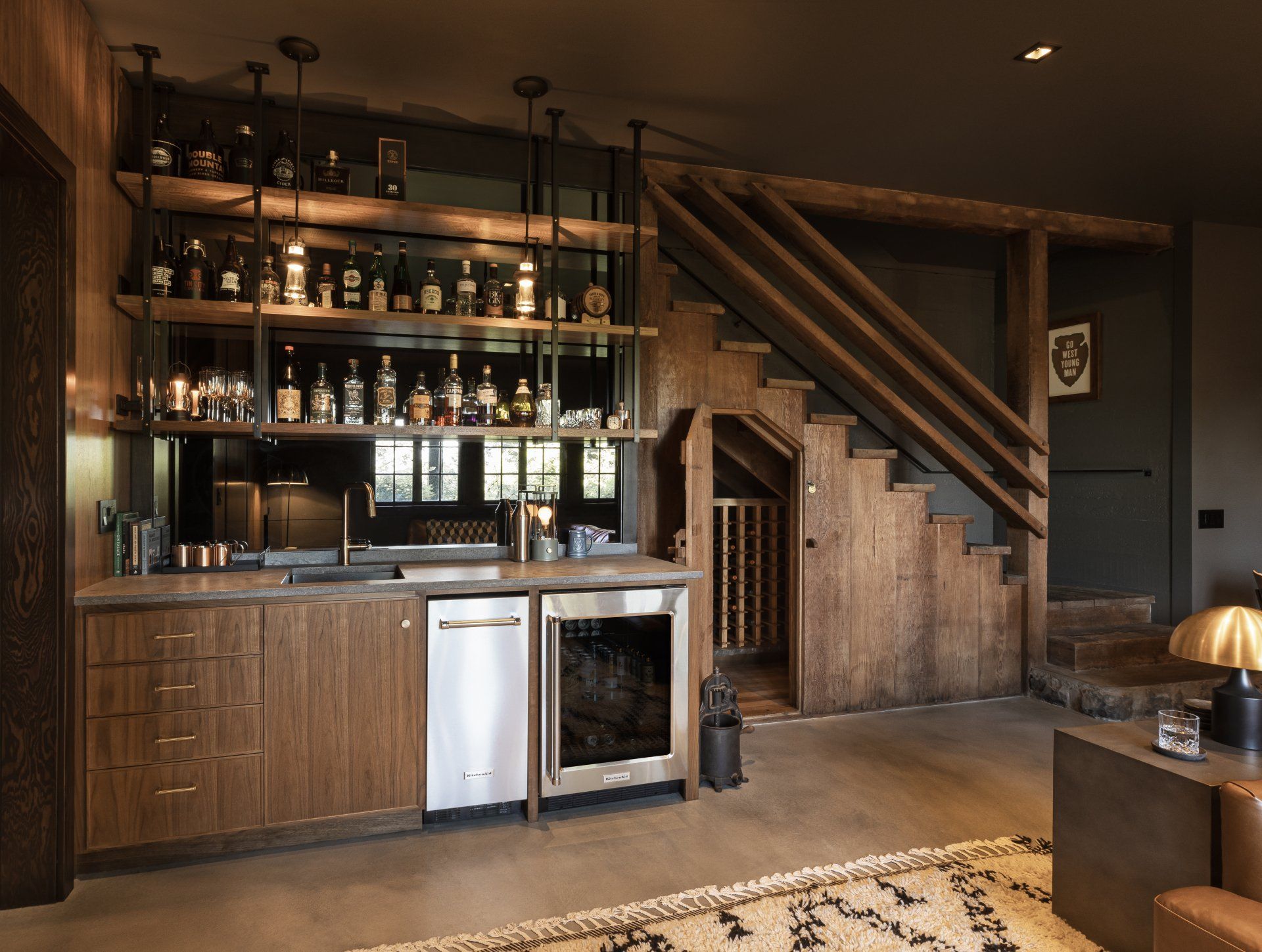 In the basement bar, the mirrored backsplash bounces natural light into the cozy tv room. 