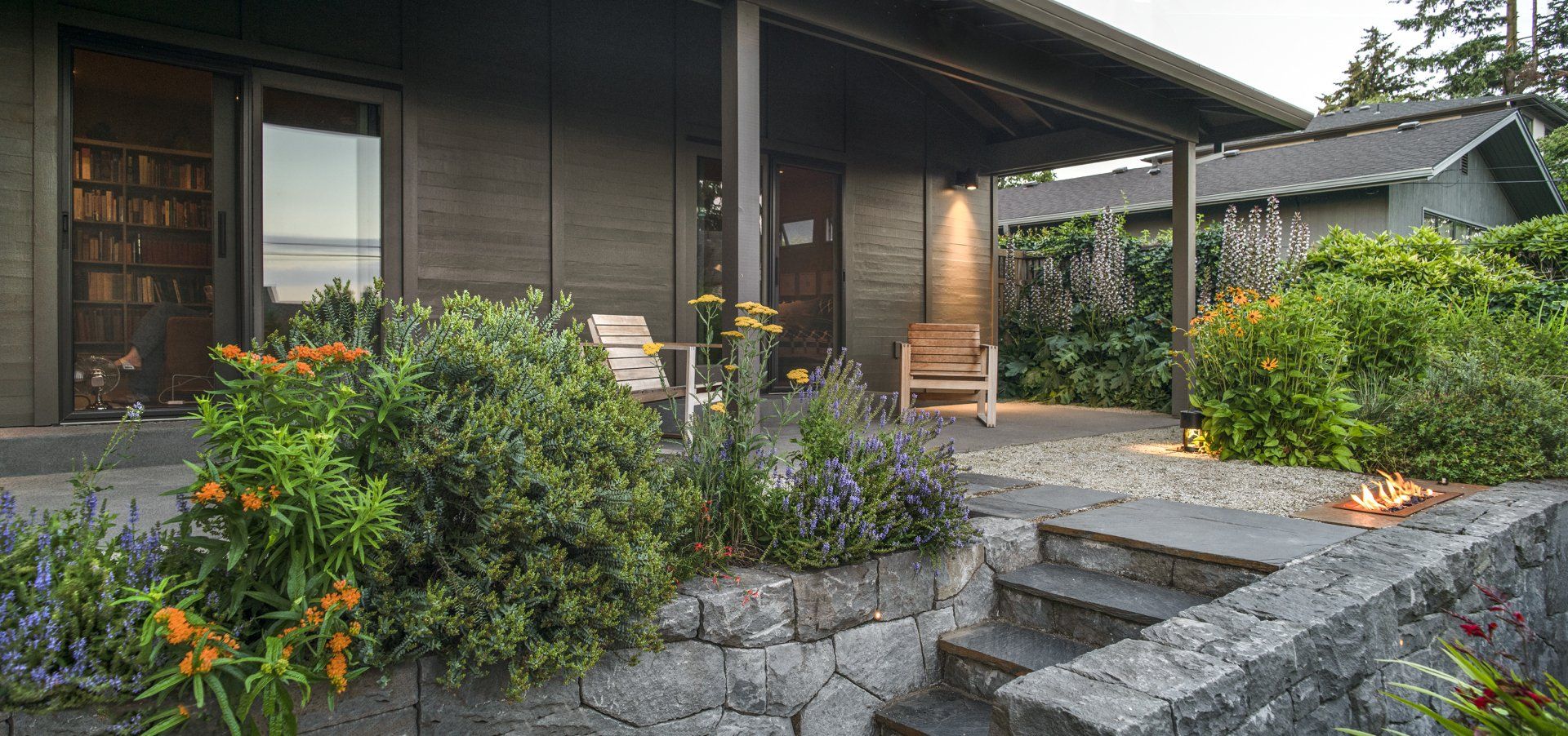 The covered patio was added to the front of the ranch home and has steps into the garden.