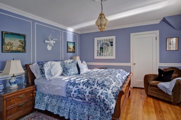 A bedroom with purple walls and a blue bed