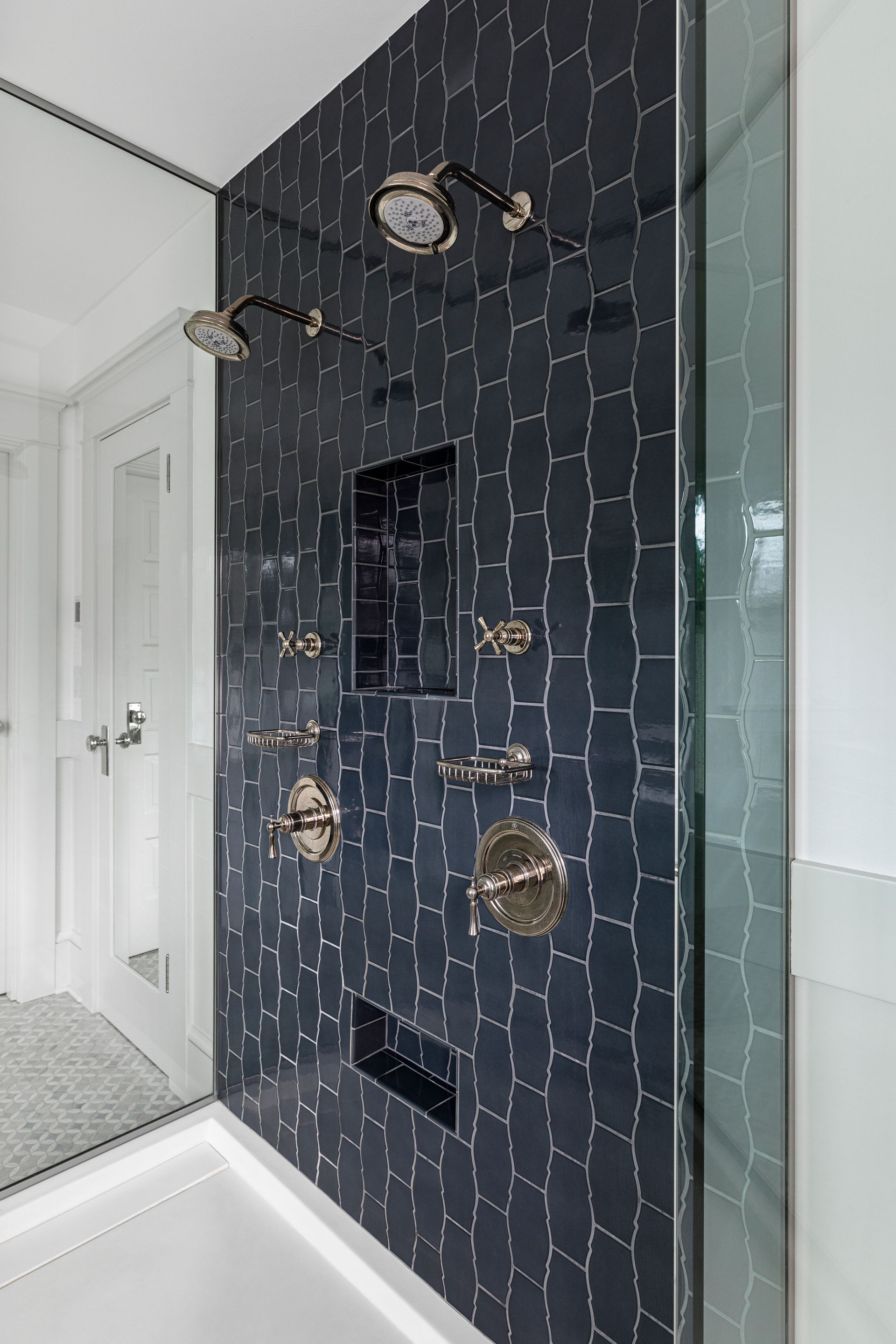 A three-sided shower creates a dramatic feature within the elegant bathroom.