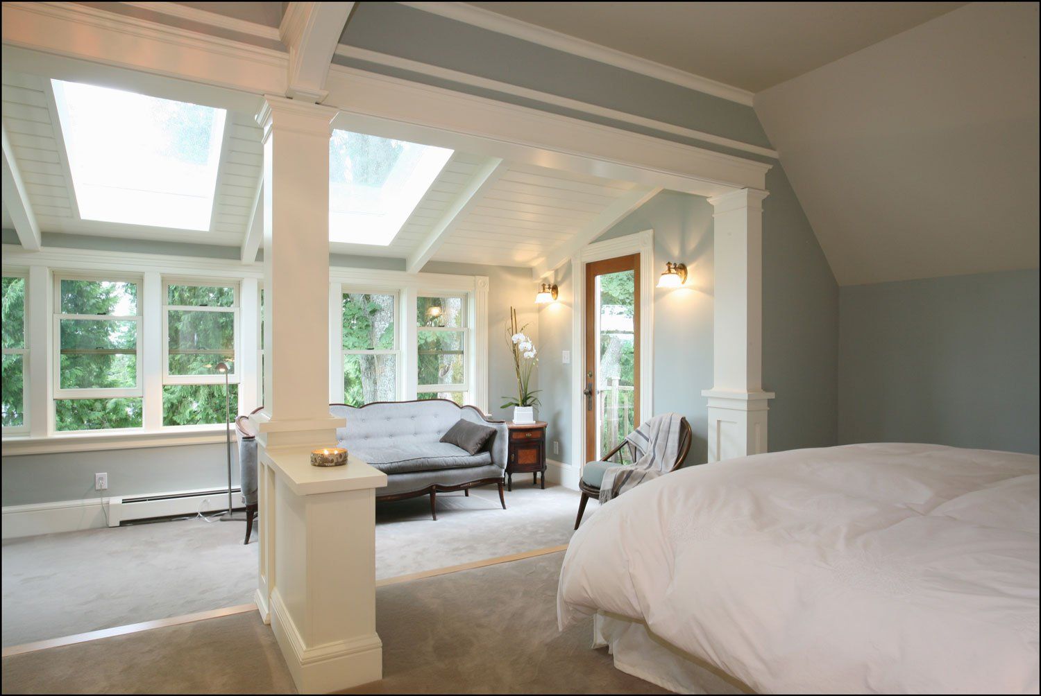 The top floor's main suite is spacious and full of light with a wall of windows.