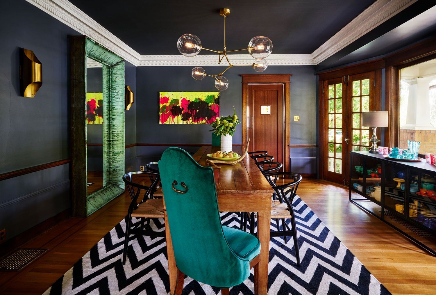 The dining room opens to the side porch, bringing in lots of light, and features favorite finishes and artwork.