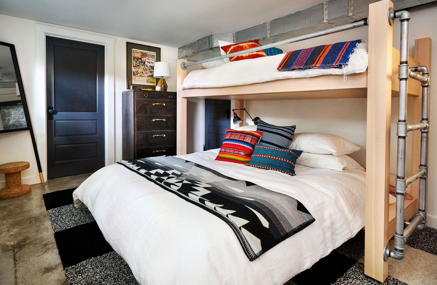 A basement bunkroom has a custom bunkbed, designed and built on site.