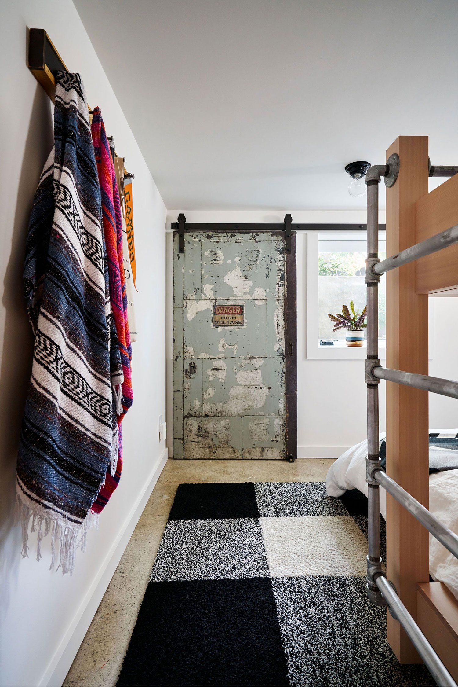 In the bunkroom, we added a high voltage door on track and rollers to cover the electrical panel. Two new egress windows allow for natural lighting.