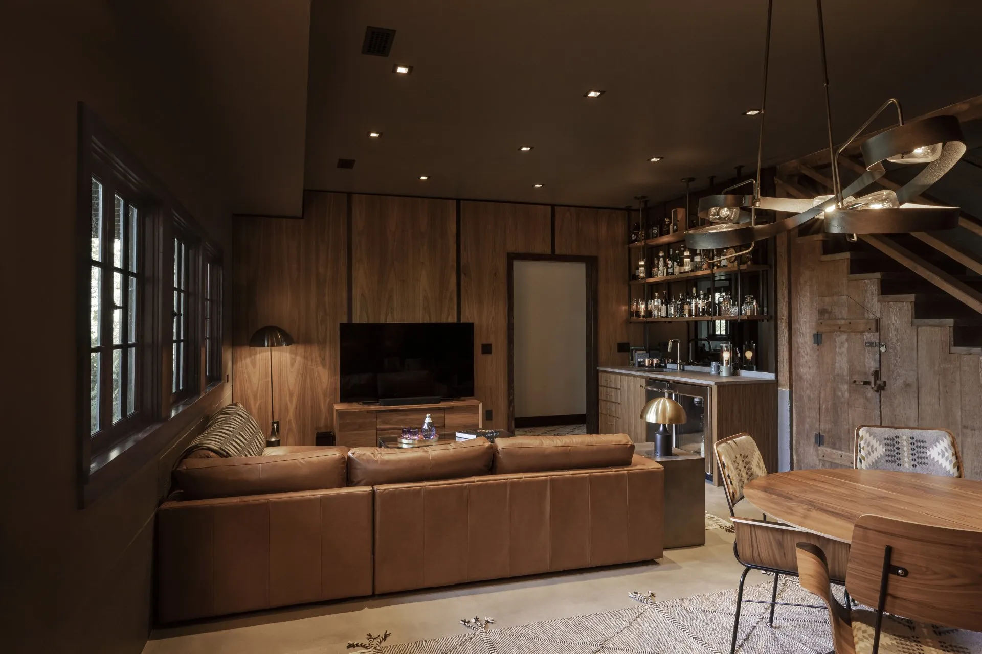 Wood paneling, leather, and concrete create a warm, earthy palette throughout the Columbia Gorge basement, proving that a darker room can feel enveloping without feeling heavy.