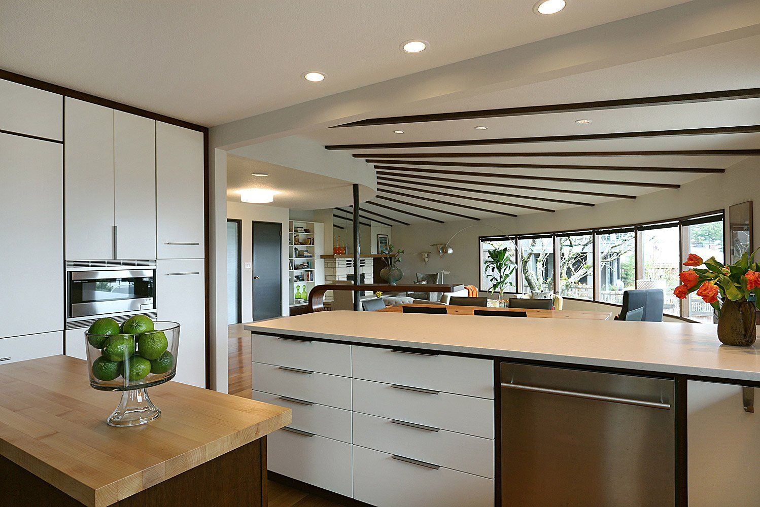 Custom walnut cabinets with white drawer & door faces pay tribute to the ceiling ribs