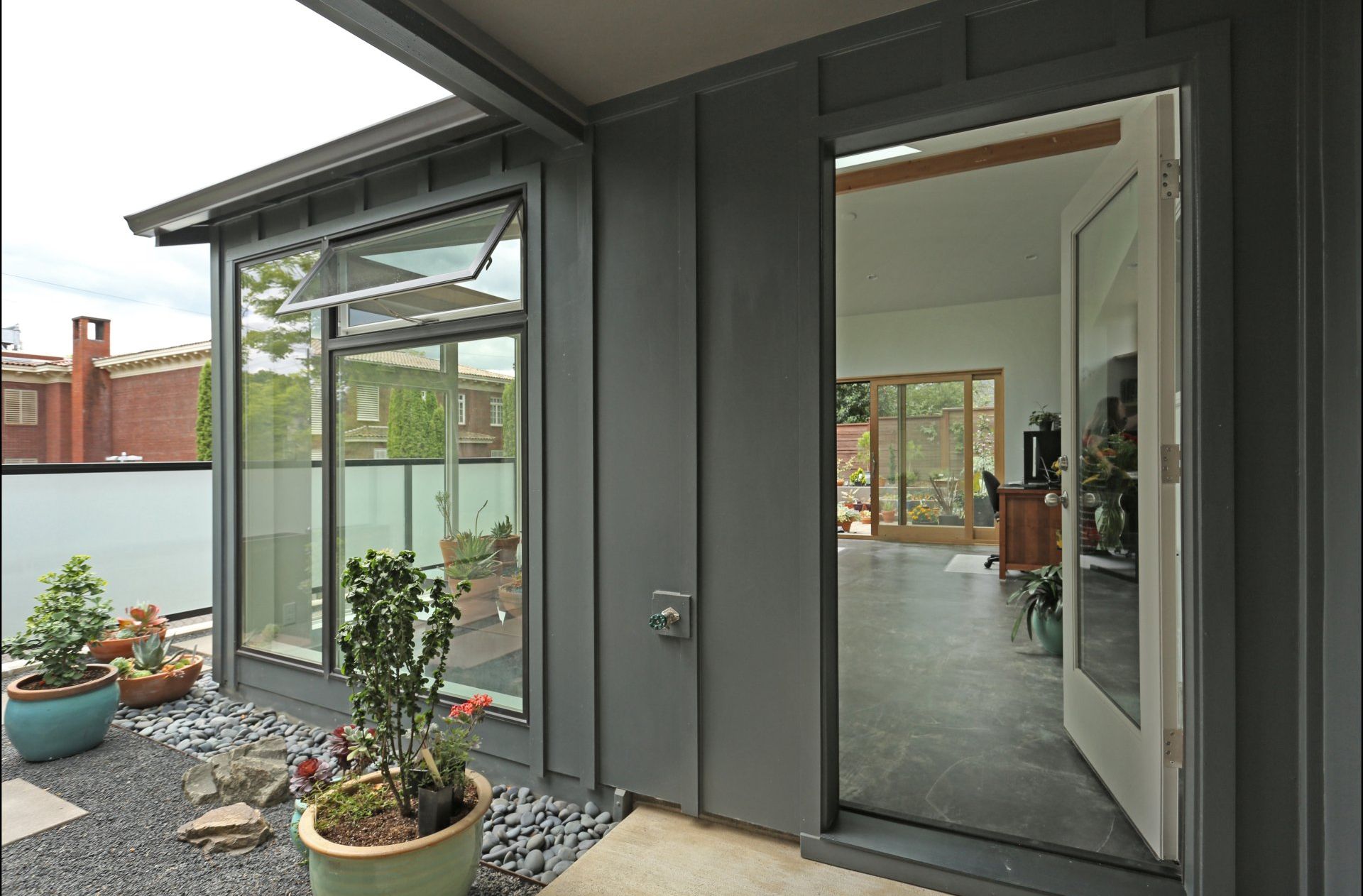 Exterior view of the new, deep gray addition at the door.