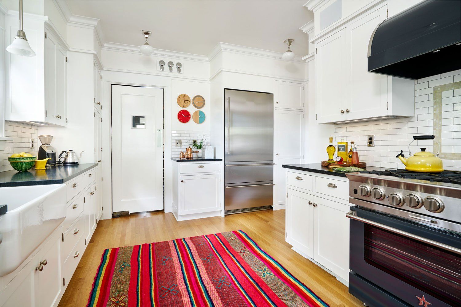 Existing kitchen cabinets were kept but painted white, and soapstone counters and period-appropriate subway tile were added.