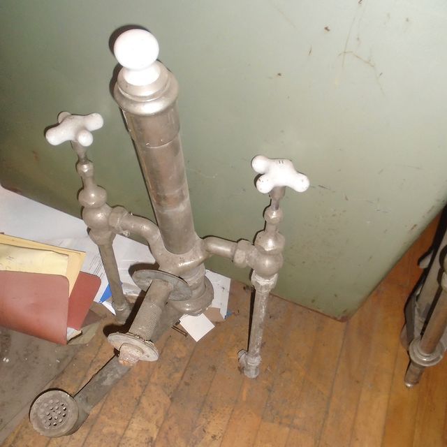 A pipe with two white handles is sitting on a wooden floor