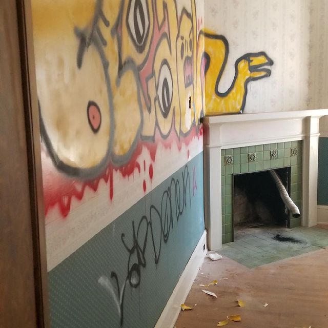 A room with graffiti on the wall including the word 