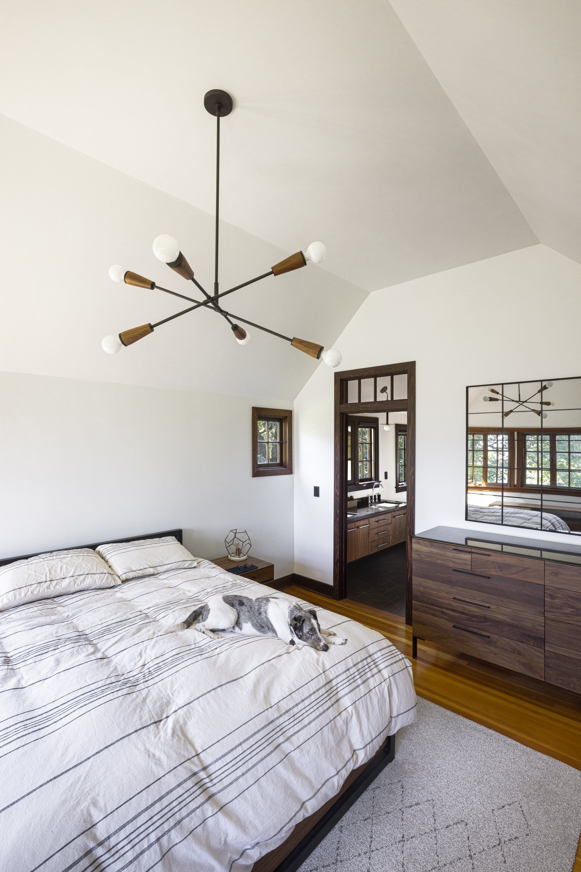 The main bedroom upstairs has a simple palette of white and wood tones.