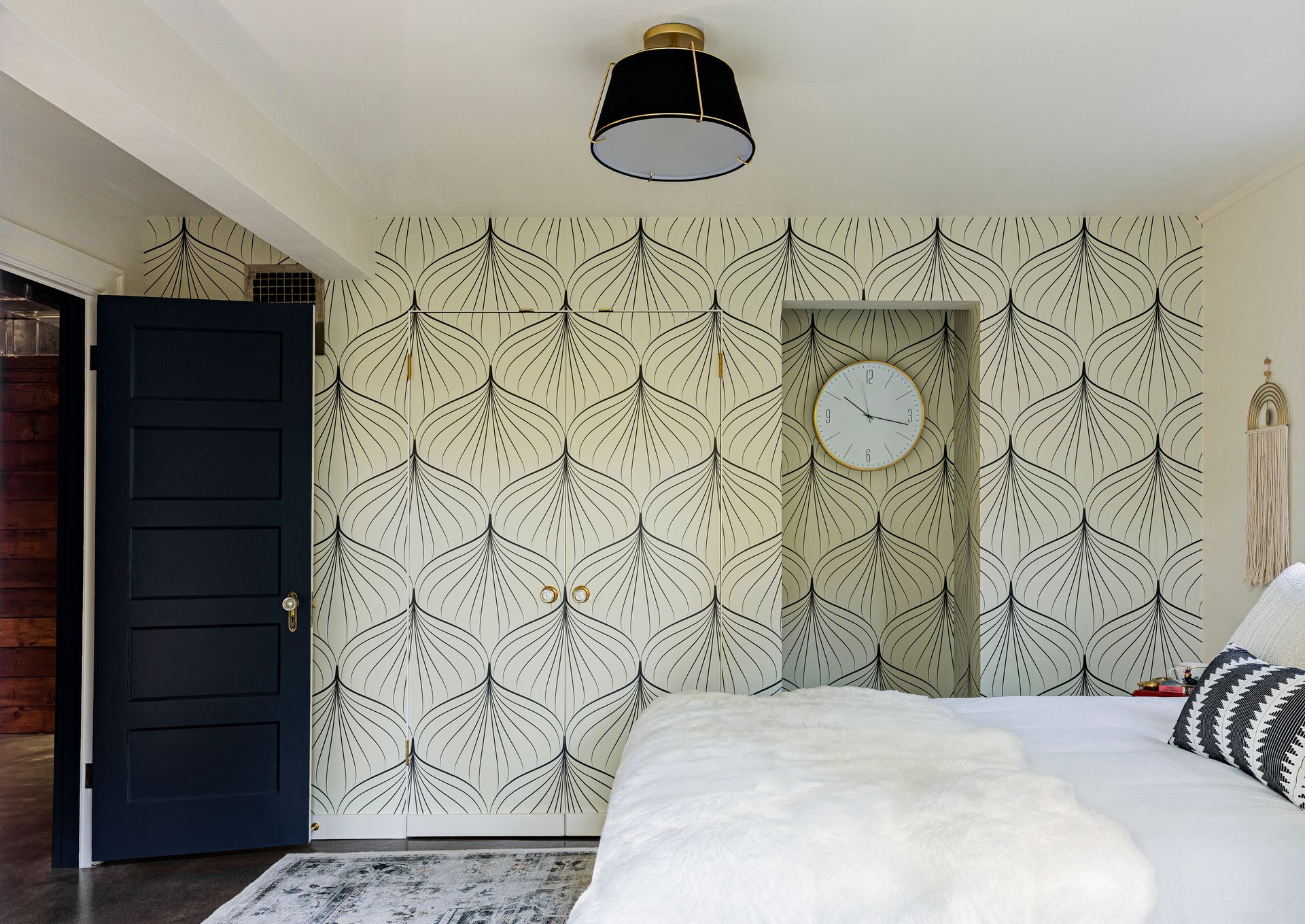 Remodeled basement guest room with black and white wallpaper.