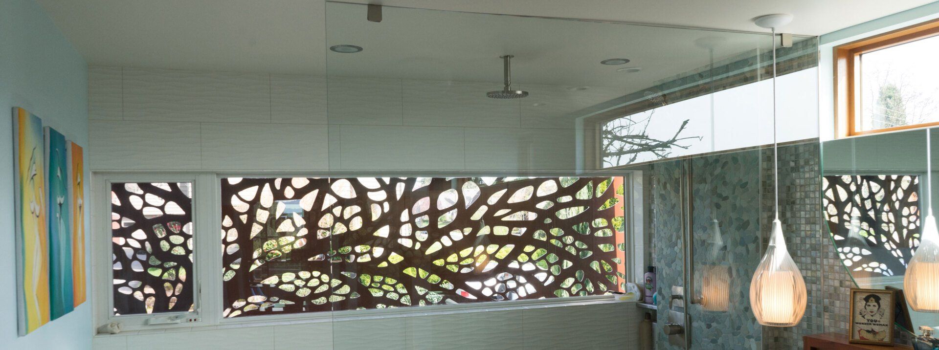 The shower window has an exterior metal screen with an organic-tree theme, made by Oregon artist Alisa Looney.