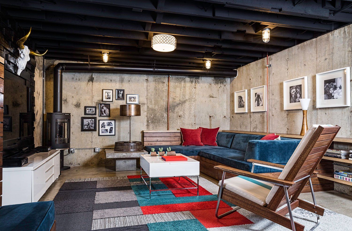 A roomy basement family room with custom, plush sectional sofa, colorful carpet tile and new corner fireplace.