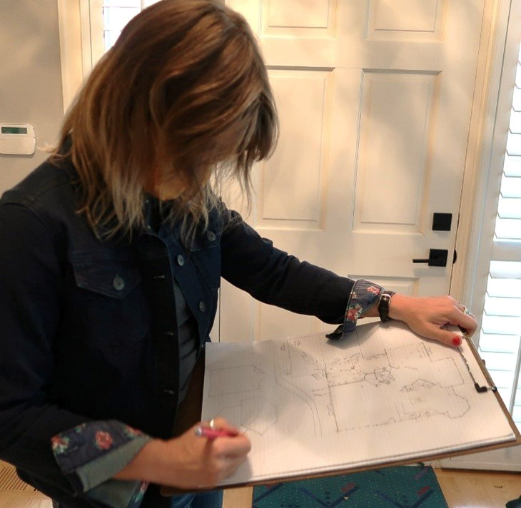 A woman is writing on a piece of paper with a marker