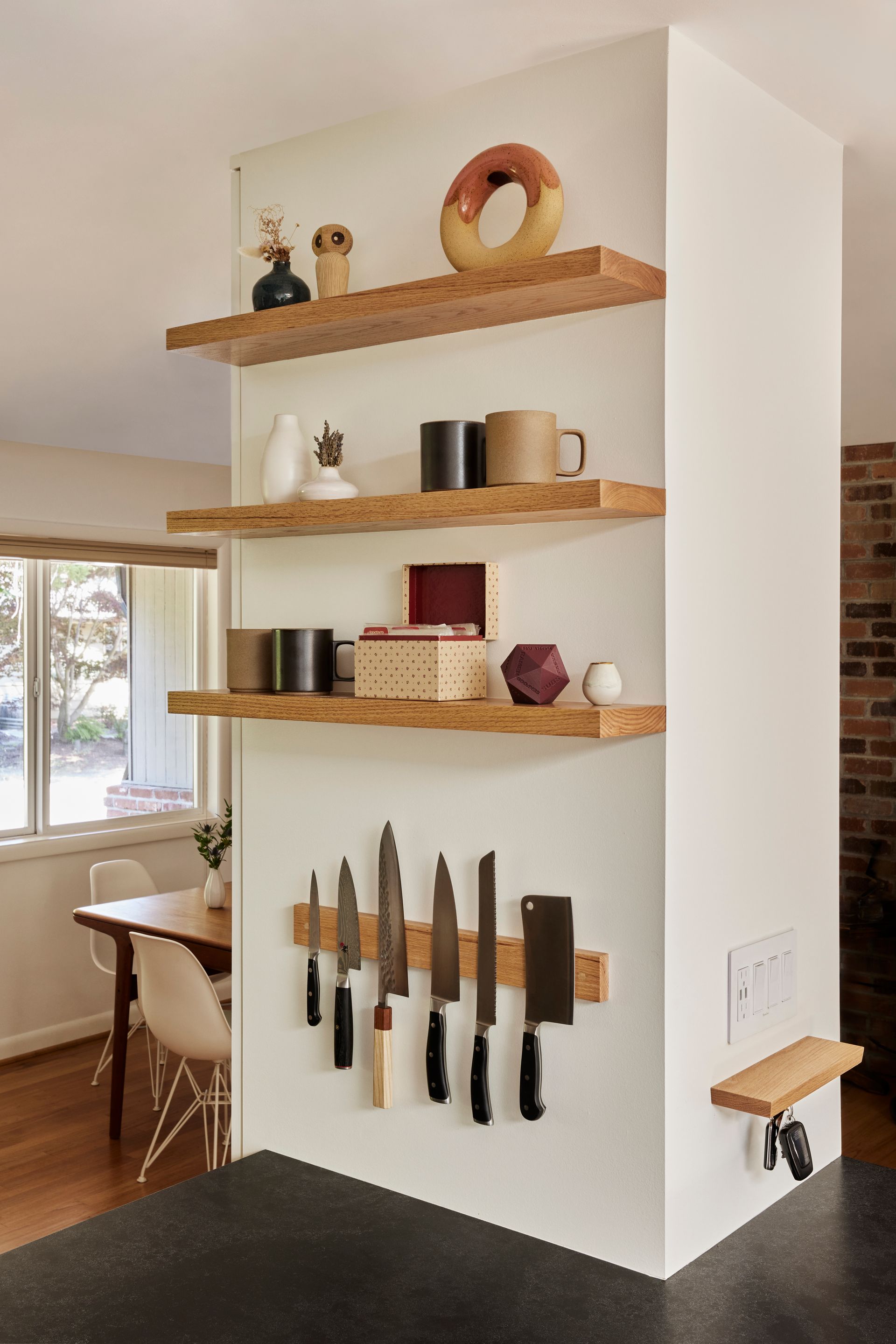 A magnet strip for knives and open wood shelves for favorite pieces provide smart storage on a vertical surface.