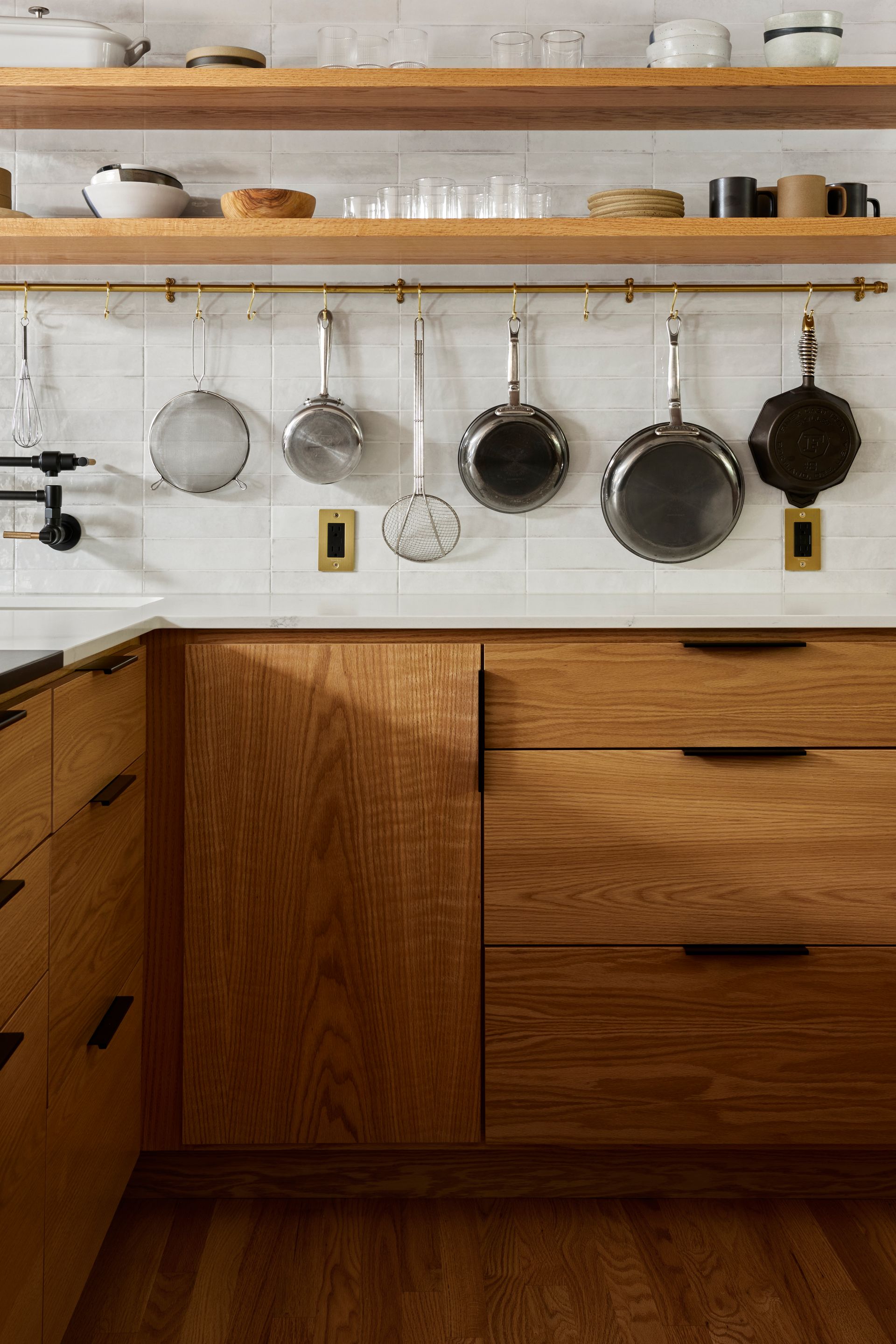 Close up of the shelving and brass pot rail over handsome stain grade lower cabinets. 