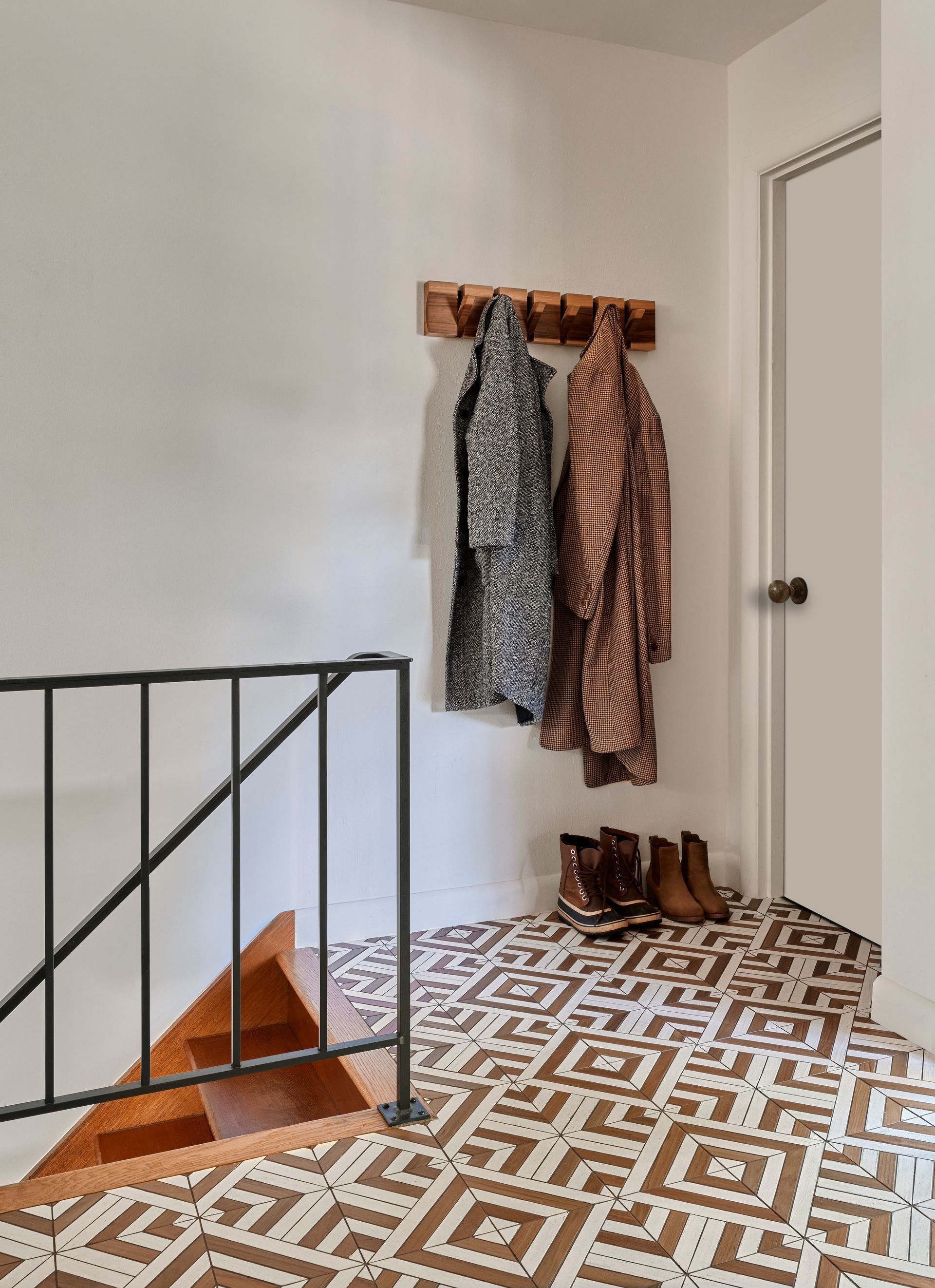 The front entry is light and bright with charming patterned teak and white floor tile.