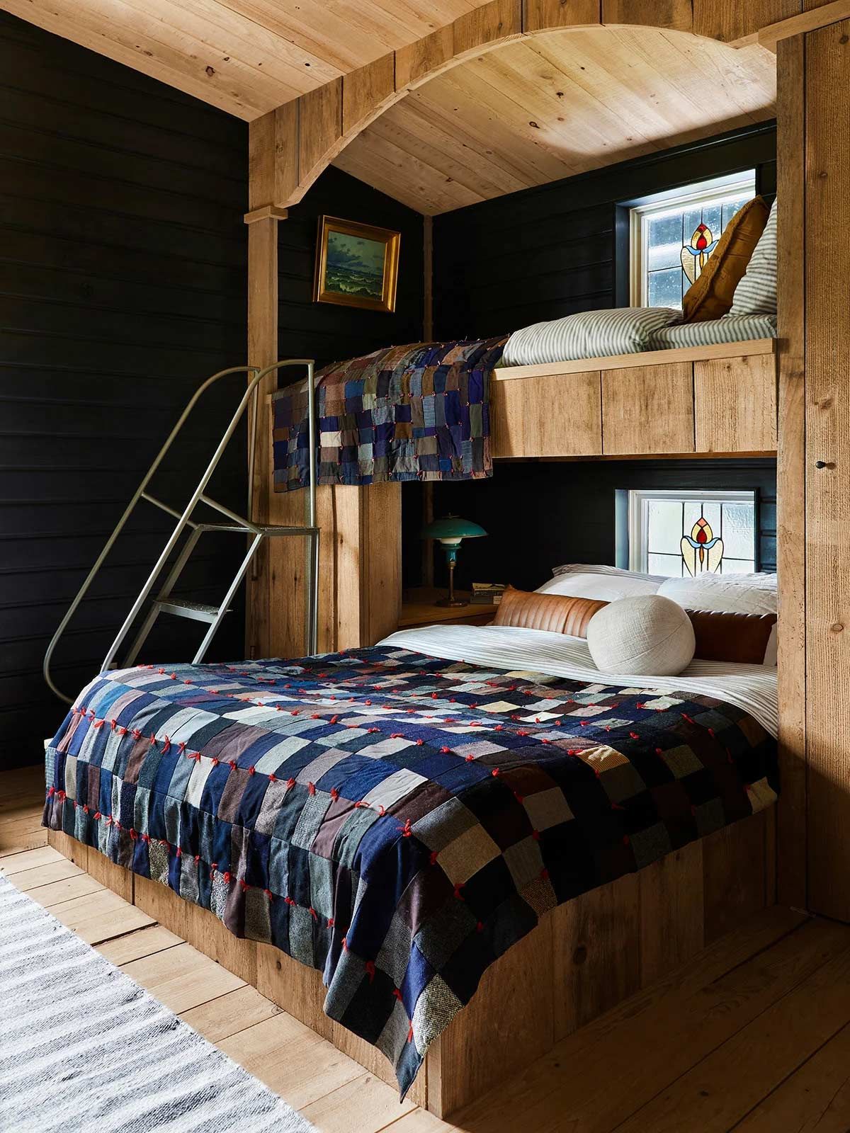 A bedroom with two bunk beds and a ladder.