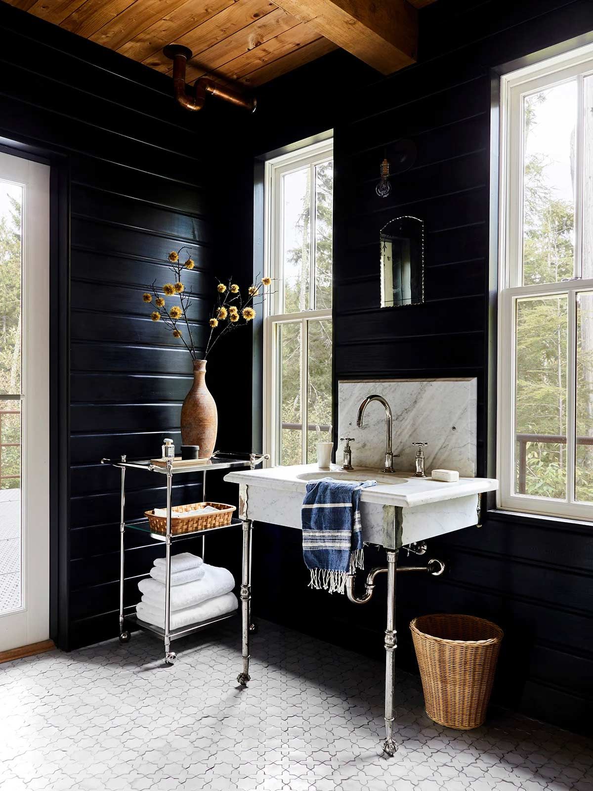 A bathroom with black walls and a white sink