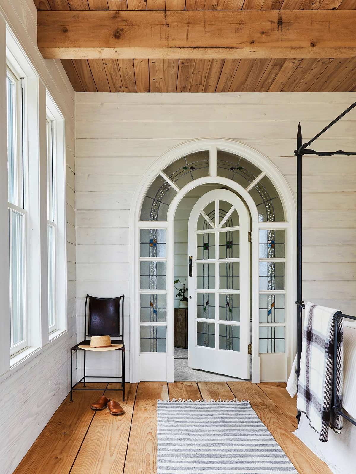 A bedroom with a canopy bed and a white door