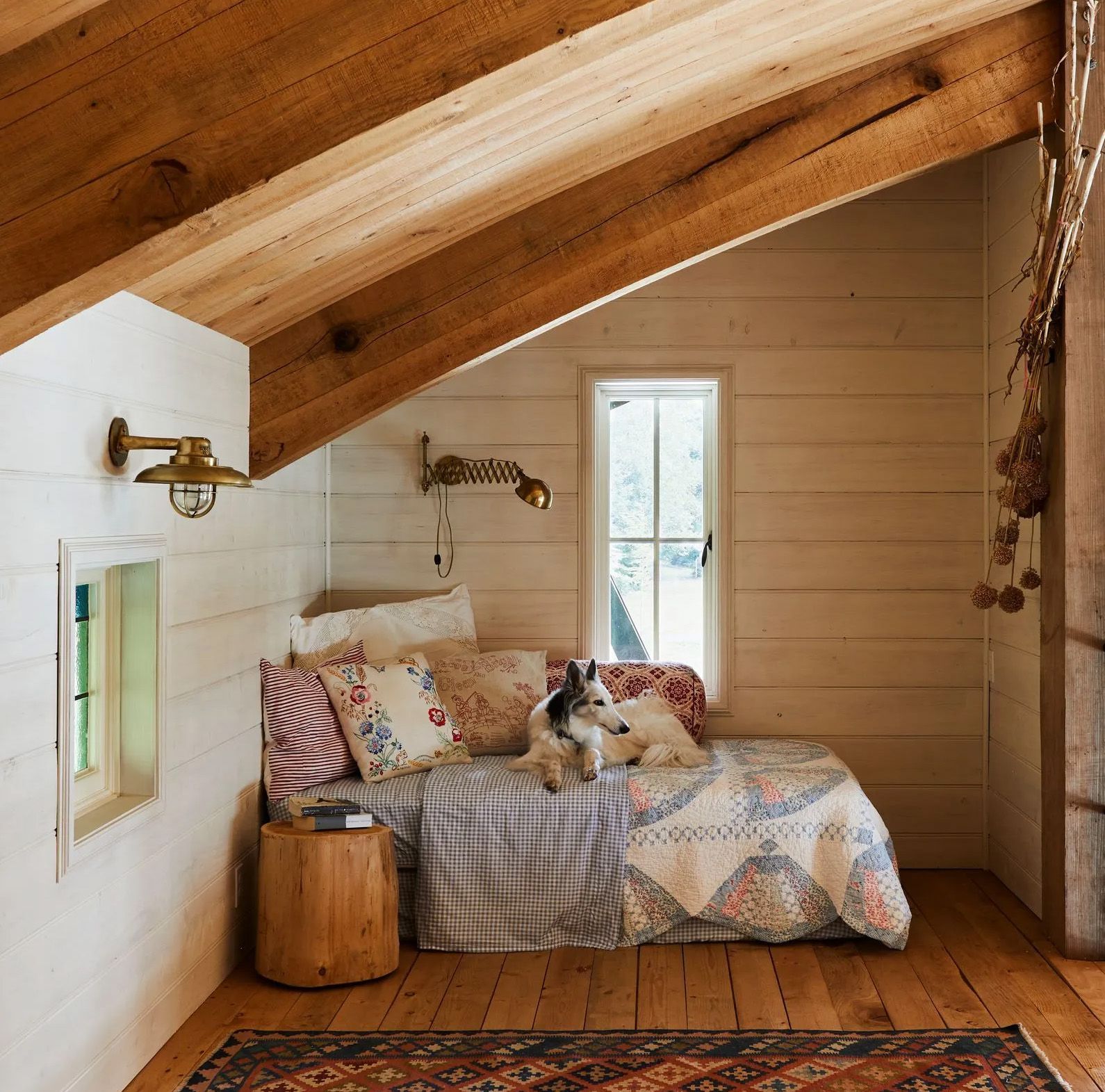 Nestled under the curving trusses of a rustic beach home, a daybed provides a cozy getaway. 