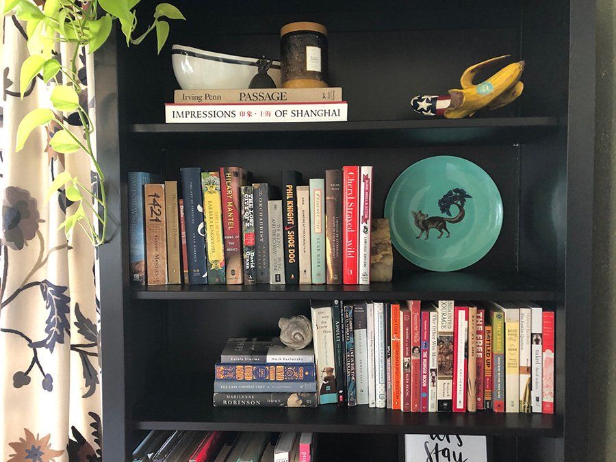 A bookshelf filled with books and a plate with a fox on it