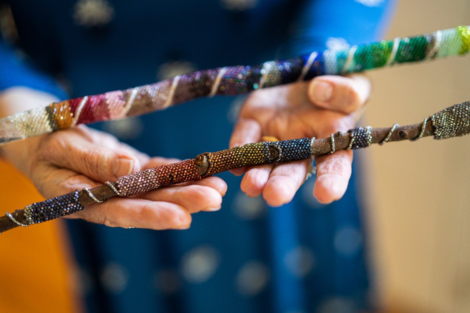 A close up of a person holding two sticks in their hands.