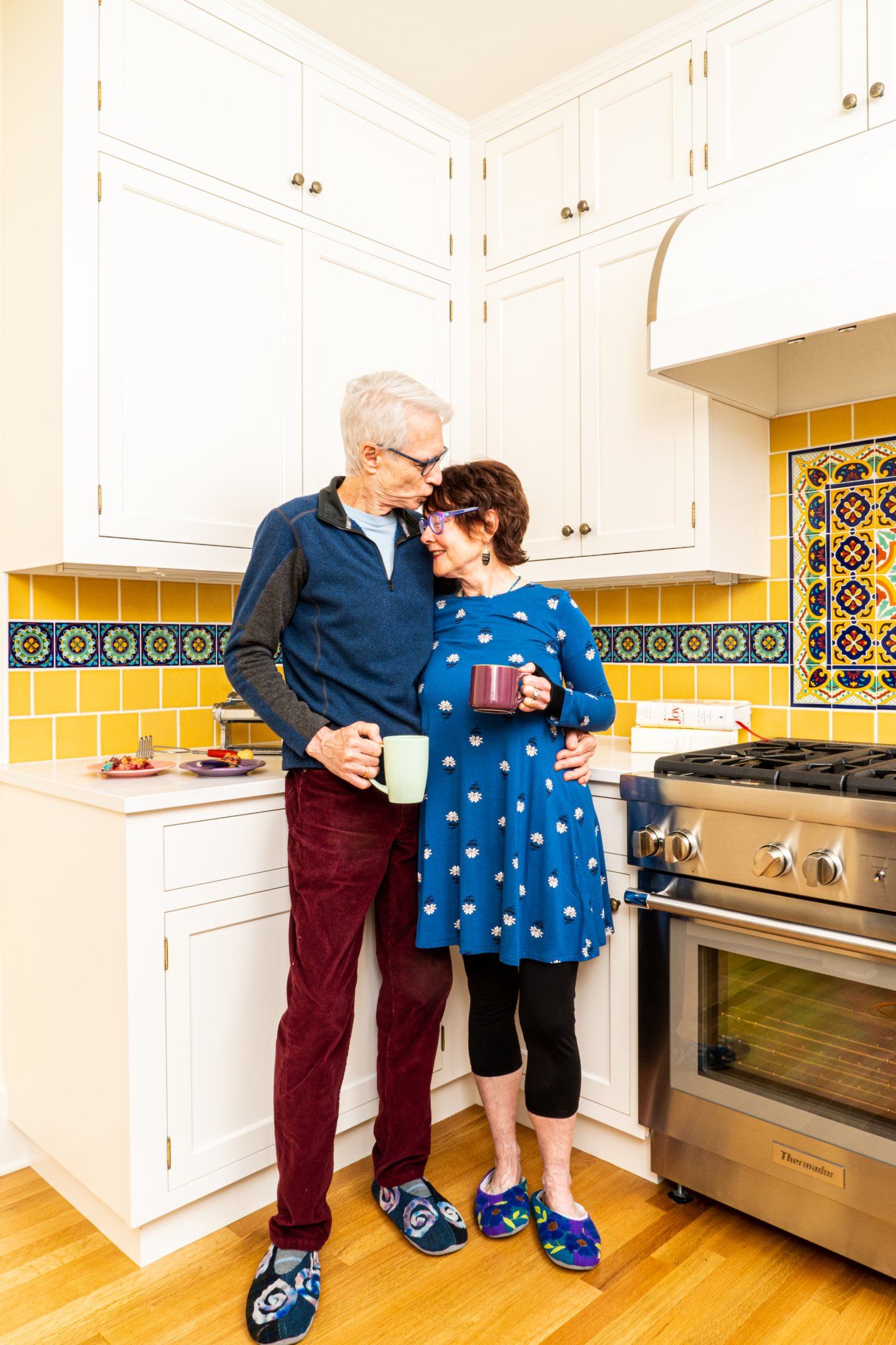 A man and a woman are standing next to each other in a kitchen.