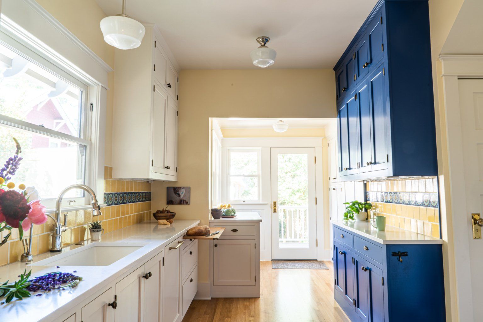 A kitchen with blue cabinets and white cabinets and a sink.