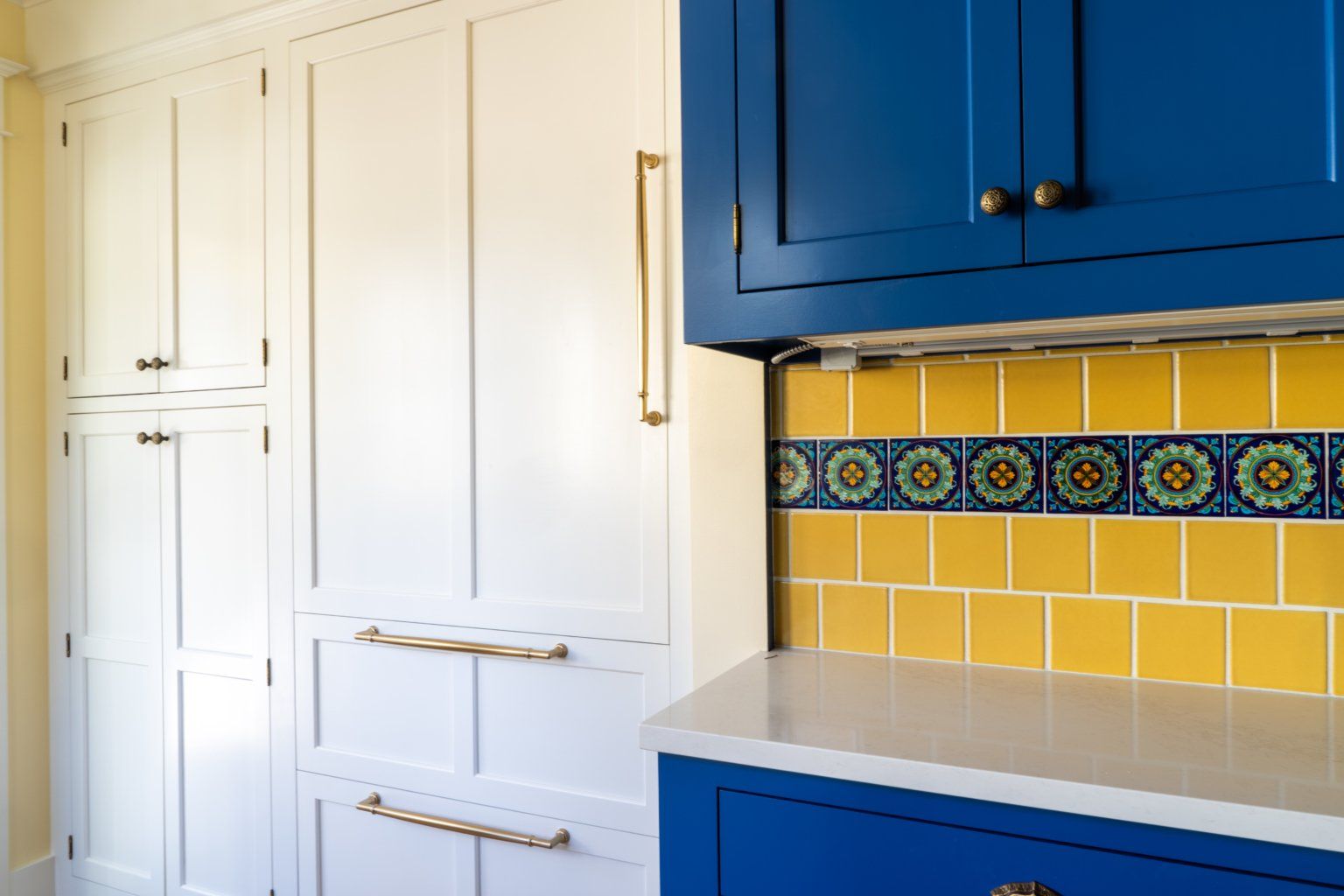 Now, near the back door, there’s a bench for removing shoes and coats, new cabinetry with an integrated refrigerator, and a place to hang coats.