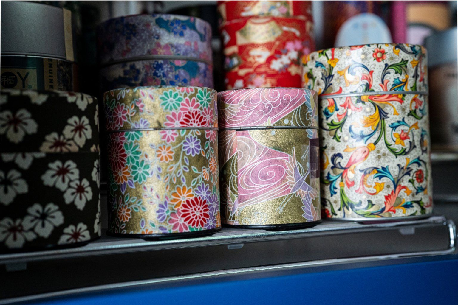 A shelf filled with a variety of boxes with different designs on them.