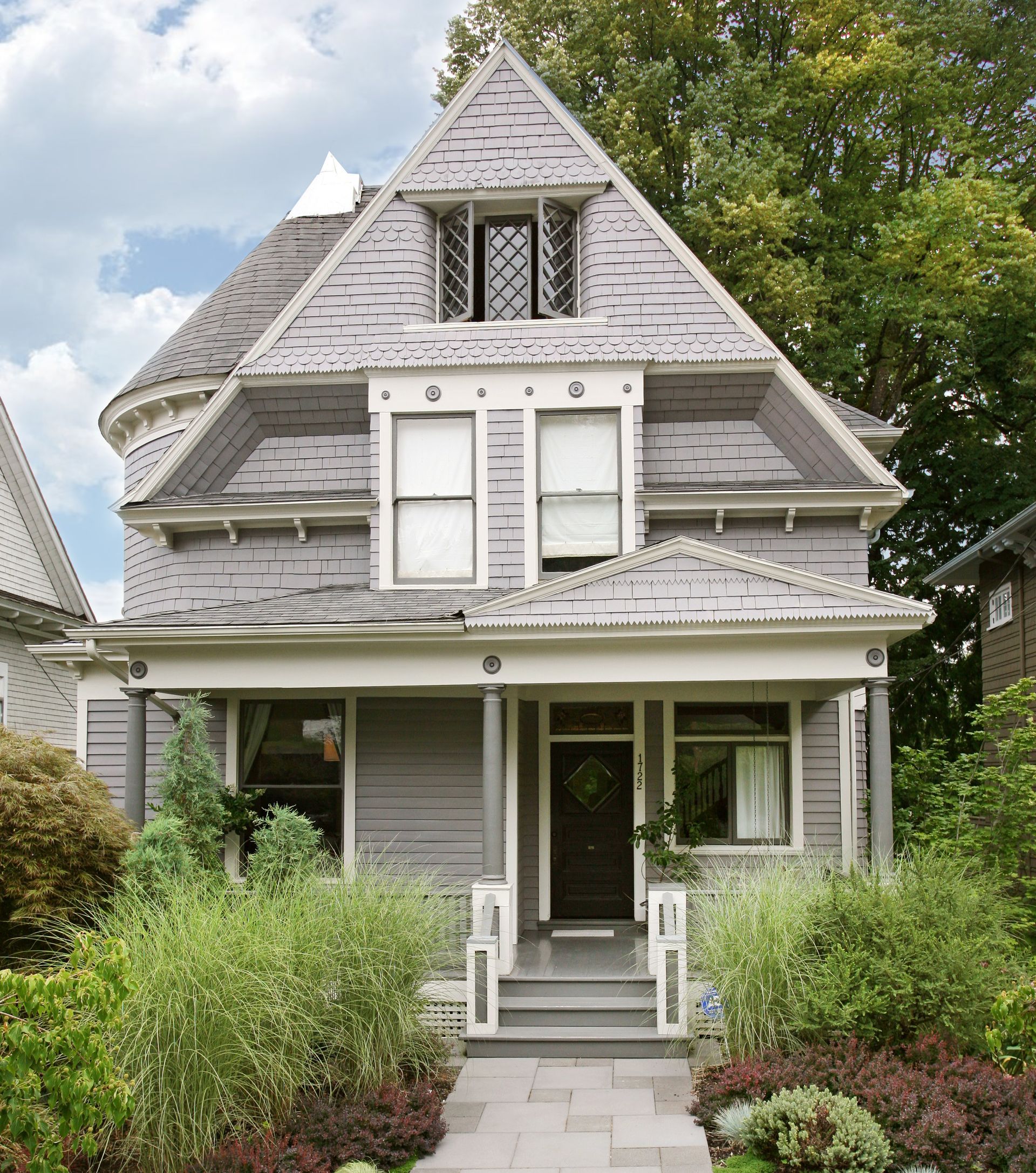 View of the front of a dove gray 1904 Queen Anne Victorian in the Northwest district in Portland.