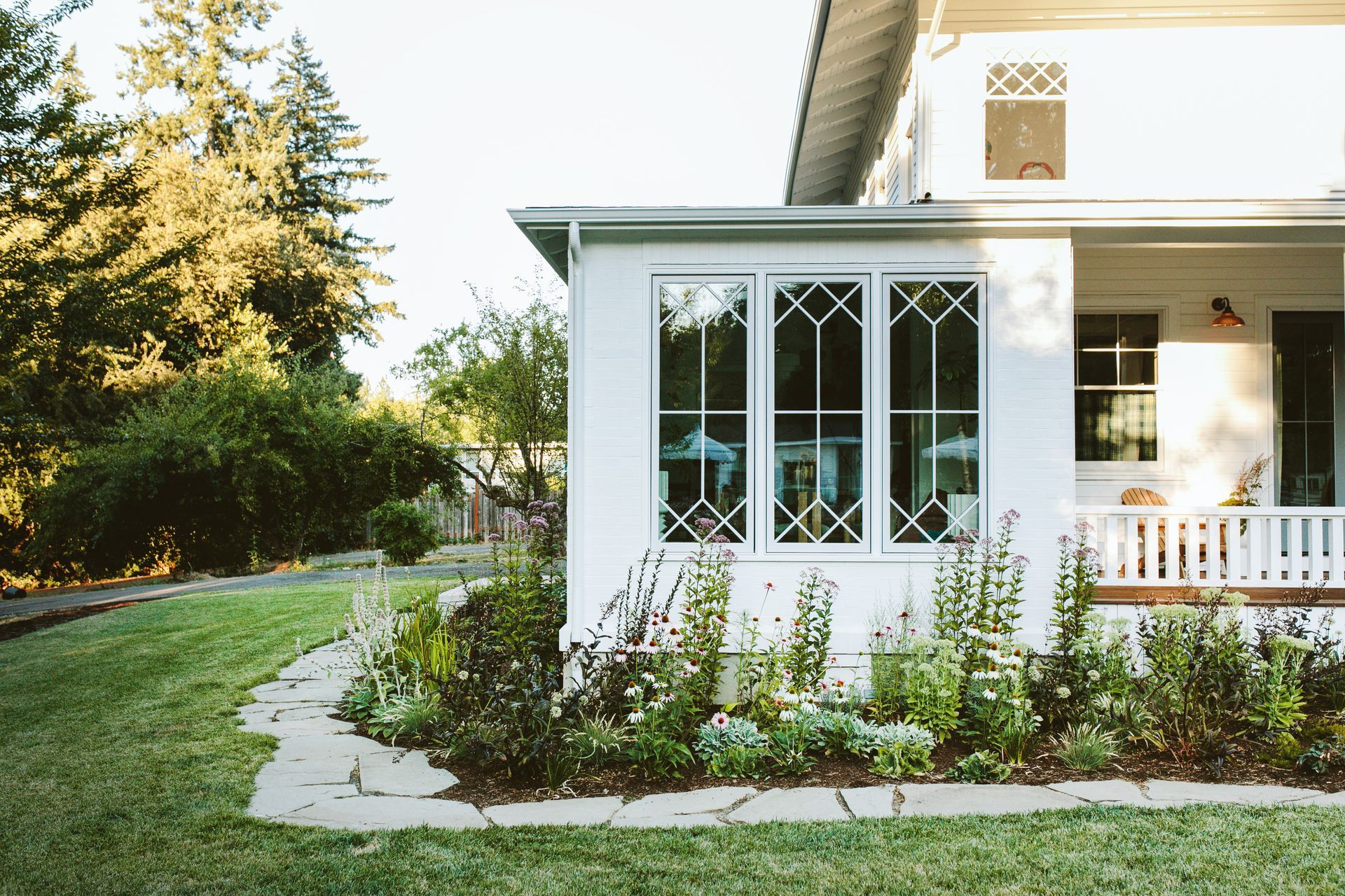 Adjacent to the new porch is a substantial sunroom addition; a second new porch fills out the side of the house.