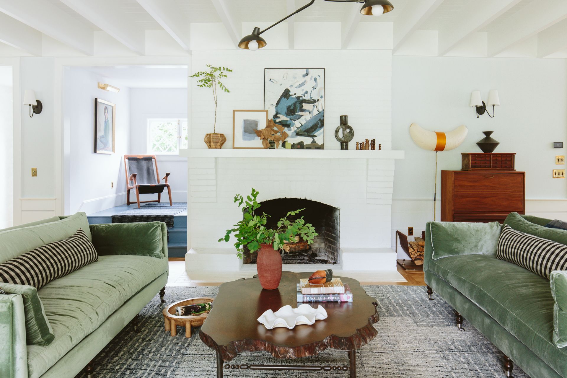 Farmhouse living room with brick fireplace and eclectic furnishings, fixtures, and finishes.