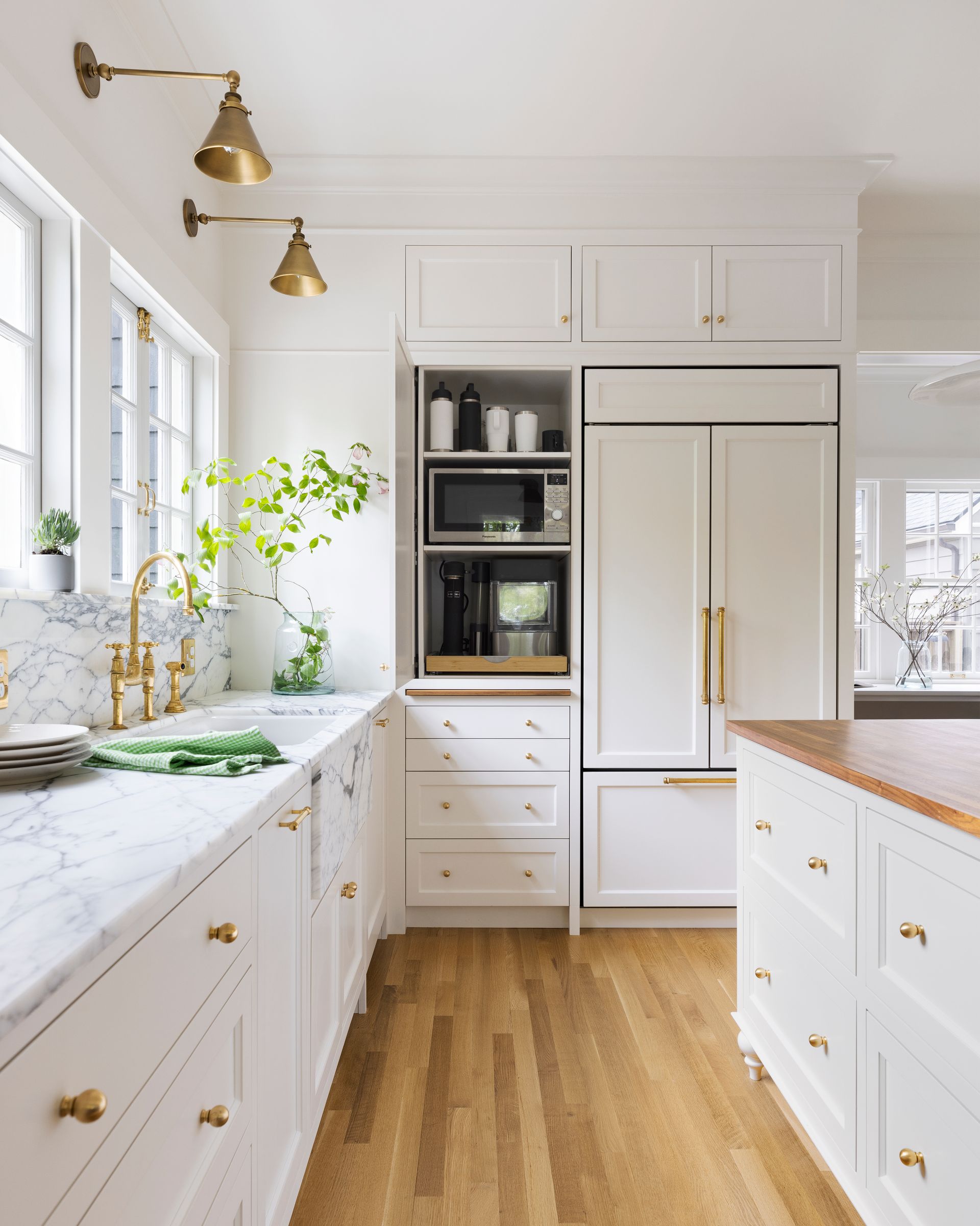 The full height cabinets, door open to show the microwave and coffee station, is nestled next to the integrated fridge. 