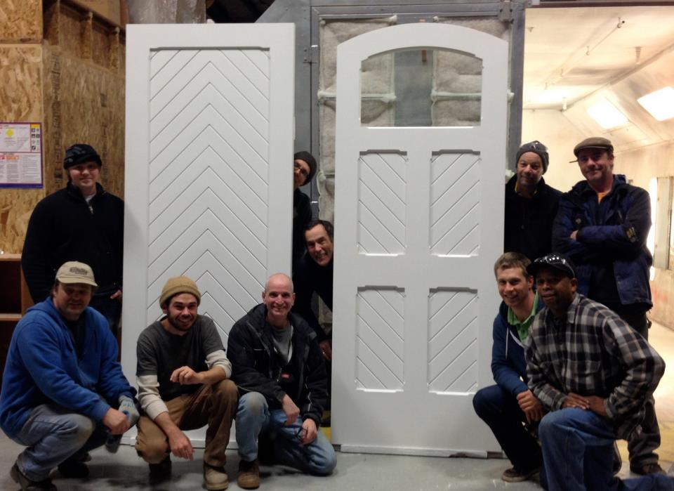 A group of people posing in front of a white door