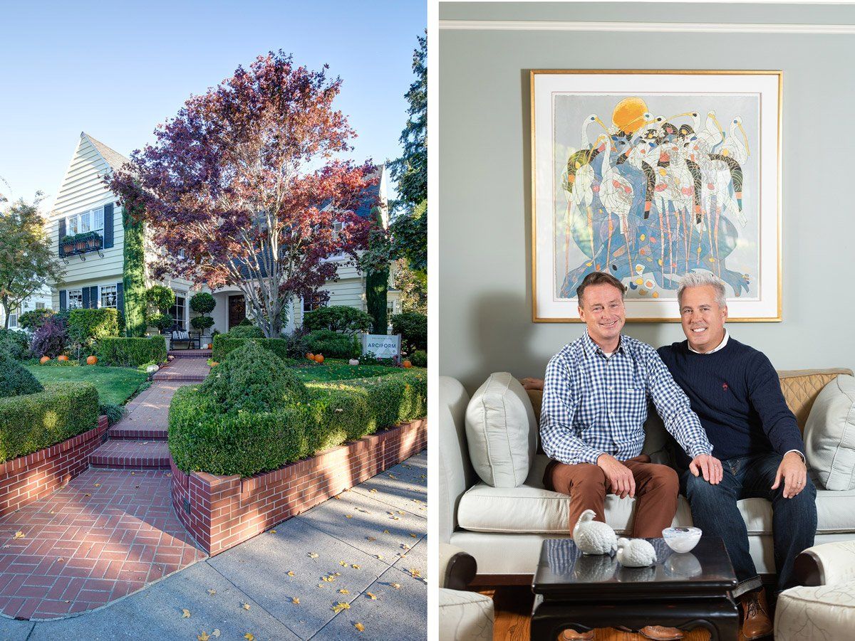 A couple of men are sitting on a couch in front of a house.