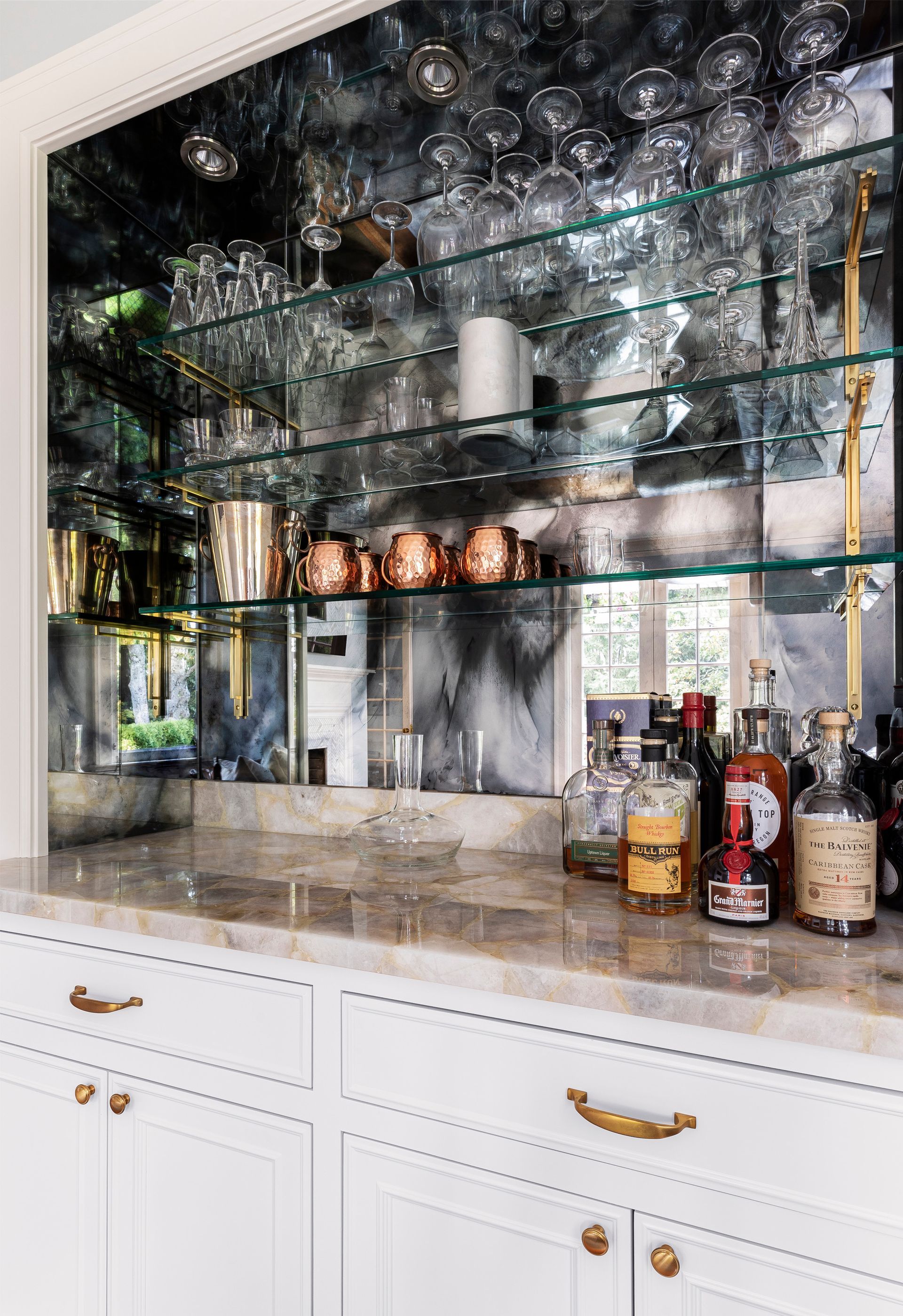 Close up view of the family room built-in bar with mirrored backsplash.