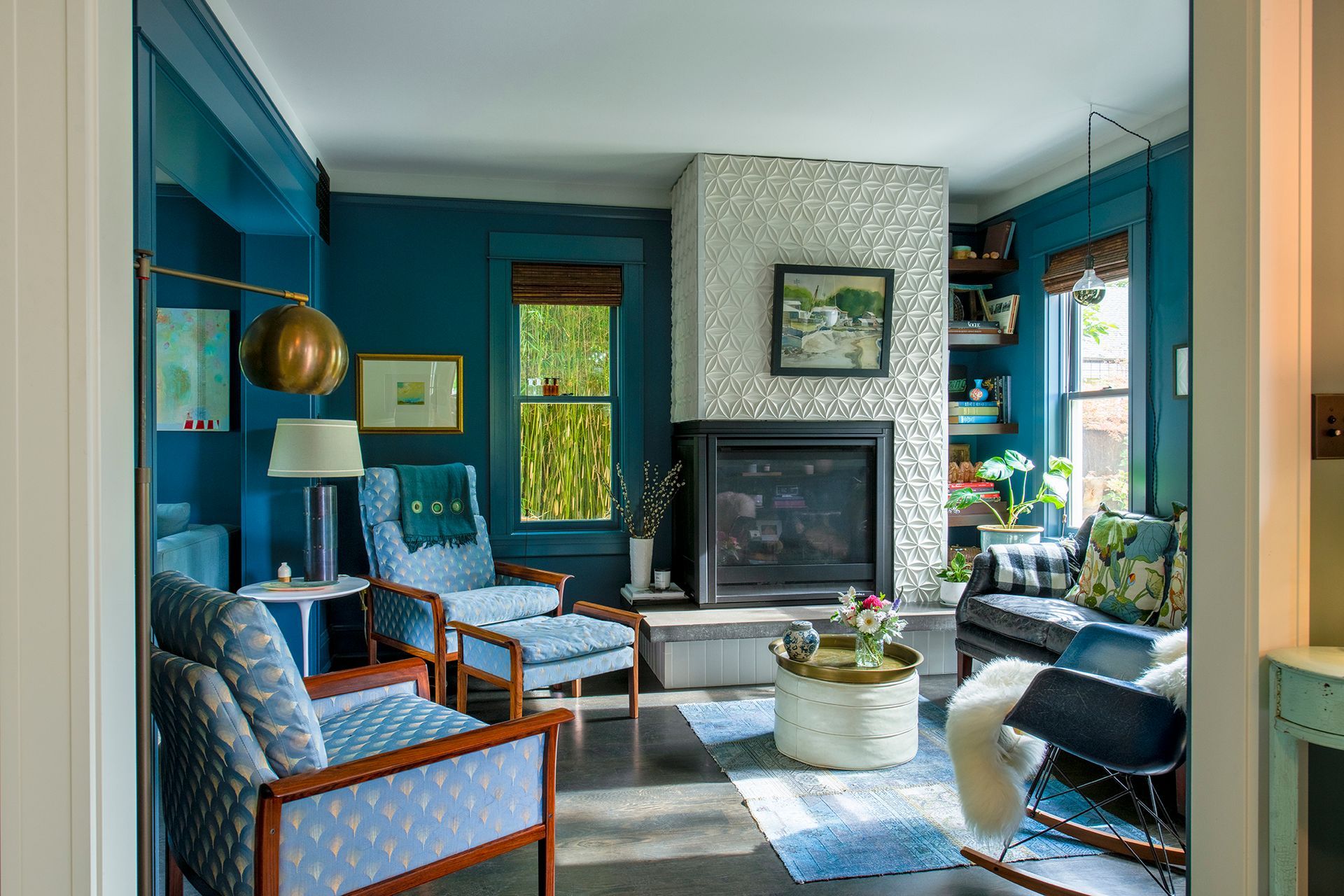 At the back of the house, a new fireplace clad in sculptural white ann sacks tile contrasts with the rich, deep blue hues on the walls and furnishings.