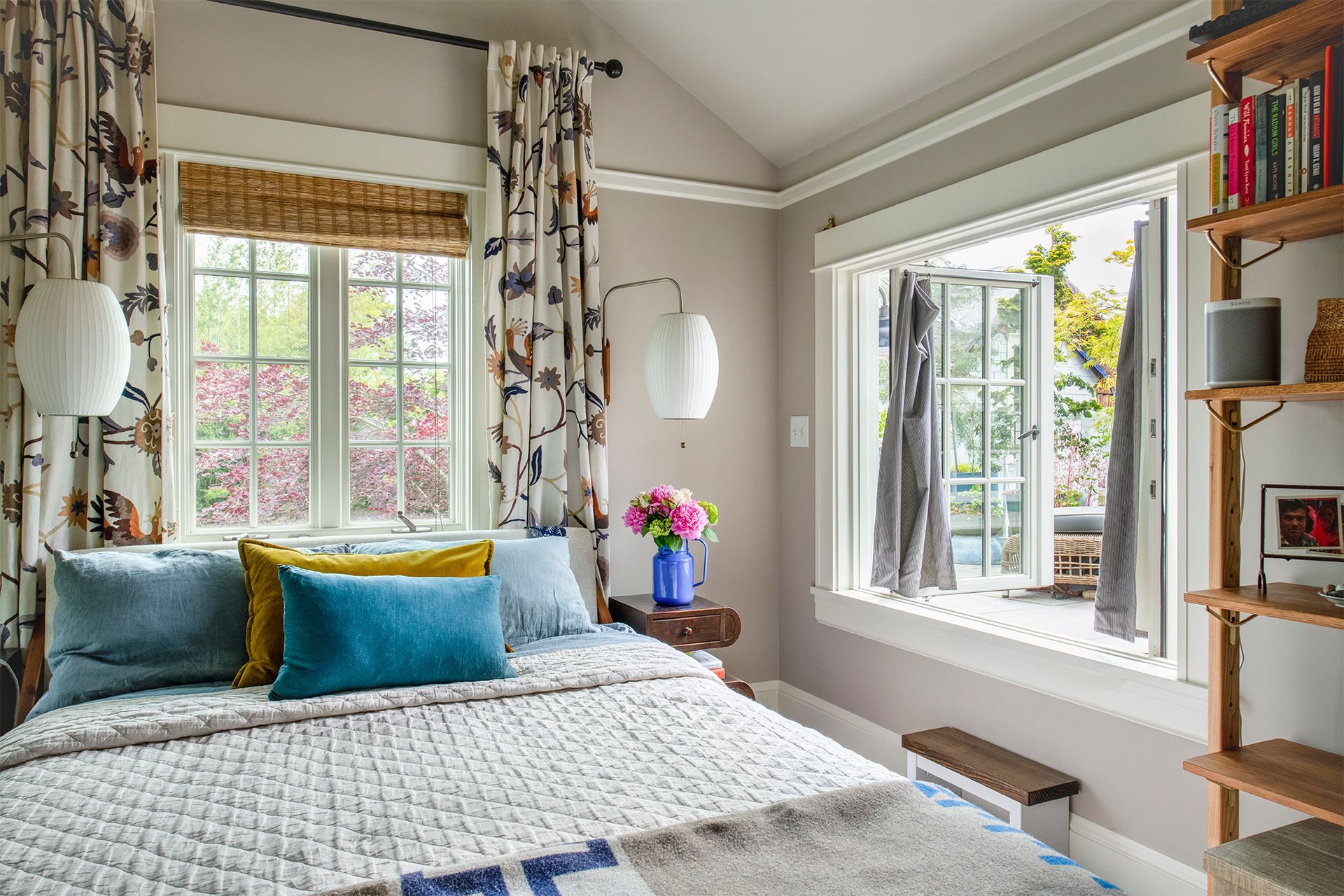 The main bedroom is serene is hushed tones and soft textures. There is a window that opens from the bedroom out to the 2nd floor balcony.